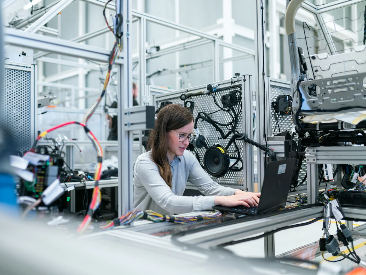 An engineer working at a laptop on the shop floor